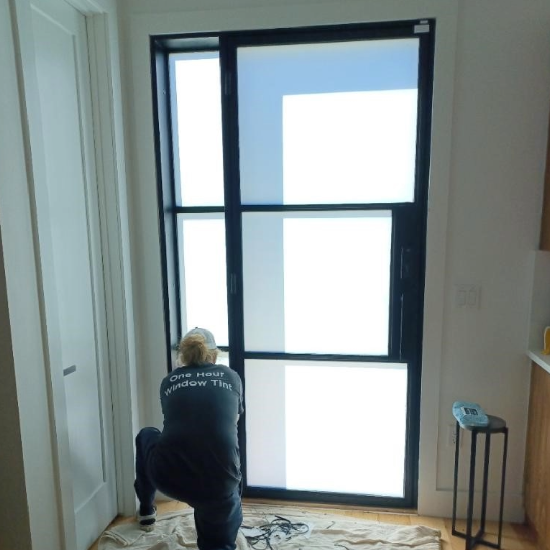 Person installing a window tint front door home blur